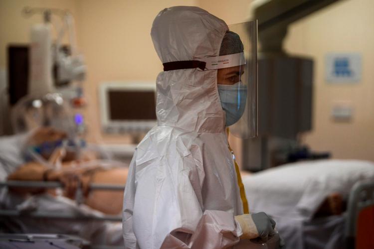 I Italien melder sundhedsmyndighederne igen om svimlende høje antal smittede, døde og indlagte med corona. Tirsdag er i alt 34.577 personer indlagt med virusset på de italienske hospitaler. På billedet ses en sundhedsmedarbejder hjælpe en covid-patient på et sygehus i Rom. Foto: Filippo Monteforte/Ritzau Scanpix