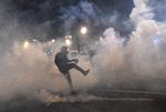 En demonstrant i sammenstød med politiet i Paris.  Over hele landet har der været demonstrationer mod en ny sikkerhedslov, som kritiseres for at være for venlig overfor politiet.  Foto: Alain Jocard/Ritzau Scanpix