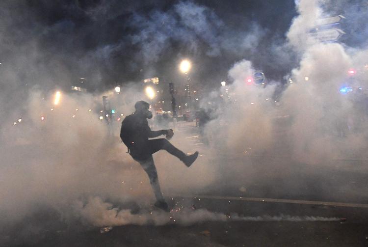 En demonstrant i sammenstød med politiet i Paris.  Over hele landet har der været demonstrationer mod en ny sikkerhedslov, som kritiseres for at være for venlig overfor politiet.  Foto: Alain Jocard/Ritzau Scanpix
