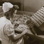 Til trods for lange samlebånd på Engelsk-Dansk Biscuits Fabrik på Nørrebro i 1944 måtte der håndarbejde til, når der skulle sprøjtes creme på kiksene, og de skulle lægges sammen. Rigsarkivet har et helt album af produktionen.  Foto: Fotograf ukendt. Affotografering: Kenn Tarbensen