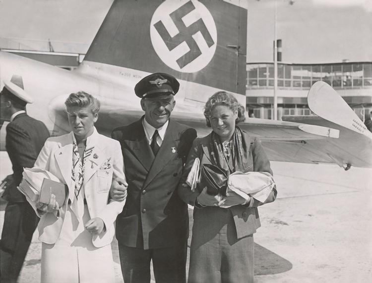 15-årige Ragnhild Hveger (tv.) og Inge Sørensen, bare 12 år, er fotograferet foran flyet til Berlin i 1936. Ved legene vandt de henholdsvis sølv og bronze. Foto: Holger Damgaard/POLFOTO