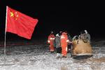 Kinesiske videnskabsfolk står rundt om rumfartøjet Chang'e-5, efter at det sent onsdag aften dansk tid landede i den kinesiske region Indre Mongoliet efter en tur til Månen. Foto: China Daily/Ritzau Scanpix