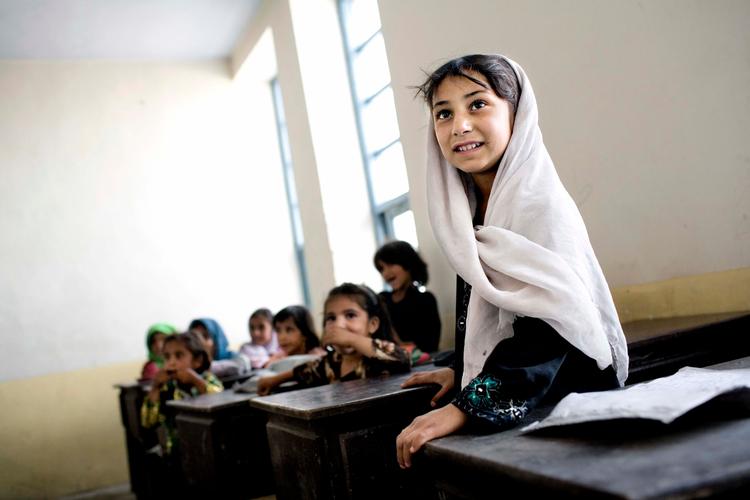     På Dosti Primary School i den krigshærgede Helmand-provins i Arghanistan undervises i toholdsskift. Nogle af børnene må sidde på lange bænke under tyndslidte telte, men de elsker at gå i skole. Når pigerne bliver 8-9 år, skal de have tørklæde på, men det behøver ikke dække alt. Skoler, Elever, Undervisning, Piger, Mennesker.   Foto: Miriam Dalsgaard/POLFOTO