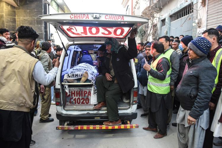 Medlemmer af det shiitiske Hazara-folk sidder bag i rustvognen ved siden af liget af et familiemedlem, der var blandt de 11 dræbte minearbejdere i det vestlige Pakistan. Foto: Banaras Khan/Ritzau Scanpix