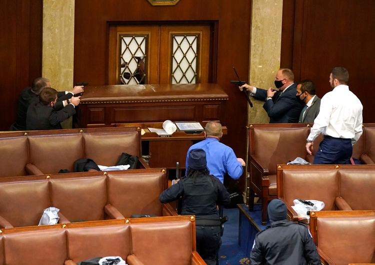 WASHINGTON, DC - JANUARY 06: U.S. Capitol police officers point their guns at a door that was vandalized in the House Chamber during a joint session of Congress on January 06, 2021 in Washington, DC. Congress held a joint session today to ratify President-elect Joe Biden's 306-232 Electoral College win over President Donald Trump. A group of Republican senators said they would reject the Electoral College votes of several states unless Congress appointed a commission to audit the election results. Drew Angerer/Getty Images/AFP == FOR NEWSPAPERS, INTERNET, TELCOS &amp; TELEVISION USE ONLY == Foto: Drew Angerer/Ritzau Scanpix