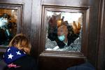     WASHINGTON, DC - JANUARY 06: A Capitol police officer looks oout of a broken window as protesters gather on the U.S. Capitol Building on January 06, 2021 in Washington, DC. Pro-Trump protesters entered the U.S. Capitol building after mass demonstrations in the nation's capital during a joint session Congress to ratify President-elect Joe Biden's 306-232 Electoral College win over President Donald Trump. Tasos Katopodis/Getty Images/AFP == FOR NEWSPAPERS, INTERNET, TELCOS &amp; TELEVISION USE ONLY ==   Foto: Tasos Katopodis/Ritzau Scanpix