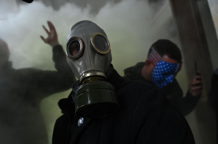 Trump-supporterne var så velforberedte, da de trængte ind i Kongressen, at nogle af dem havde gasmasker på til at modstå politiets tåregas. Konservative værter på blandt andet Fox News tror ikke på, at de var 'rigtige' Trump-tilhængere. Foto: Brendan Smialowski/Ritzau Scanpix