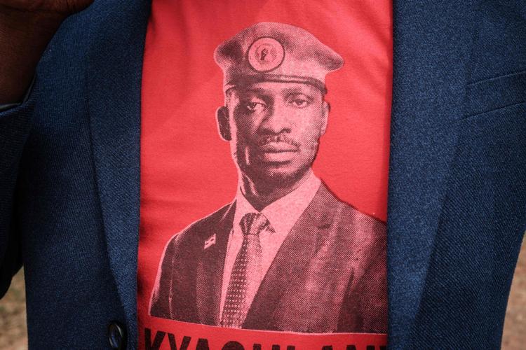 Fra en T-shirt på brystet af en af sine tilhængere kigger Bobi Wine ud mod verden med fast blik og sin karakteristiske røde baret. Foto: Yasuyoshi Chiba/Ritzau Scanpix