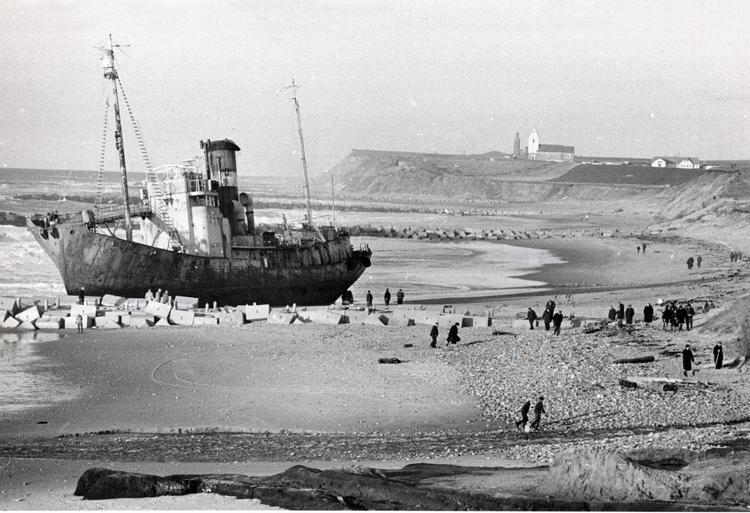 Det gamle skib var på vej fra Norge til ophugning i Belgien, da en storm i december 1966 rev trossen til slæbebåden 'Temi III' over. Skroget stod så langt oppe på stranden ved Fjaltring, at det måtte hugges op på stedet.. Foto fra bogen. 