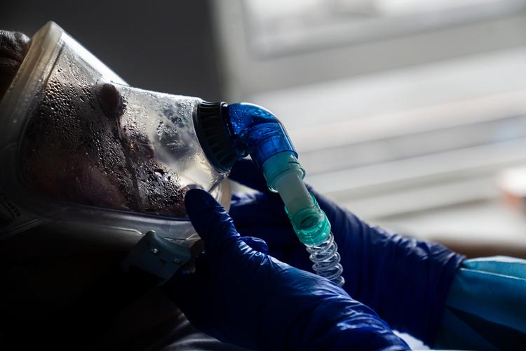 På Sjællands Universitetshospital i Køge. Virussen slider voldsomt på muskler og lungevæv, men også på psyken, når døden pludselig kommer helt tæt på. En ældre herre ligger her med en udvendig respirator, der giver ham ilt. Uden den ville han ikke kunne overleve længe. Foto: Mads Nissen/POLFOTO