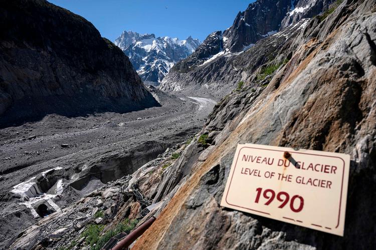   Gletcheren i Chamonix i de franske Alper i 2019. Skiltet angiver dens højde i 1990. Og siden 2019 er det blevet værre. Ifølge Météo France vil der stort set ikke være sne i dele af det franske Alper i 2100.  Foto: Marco Bertorello/Ritzau Scanpix