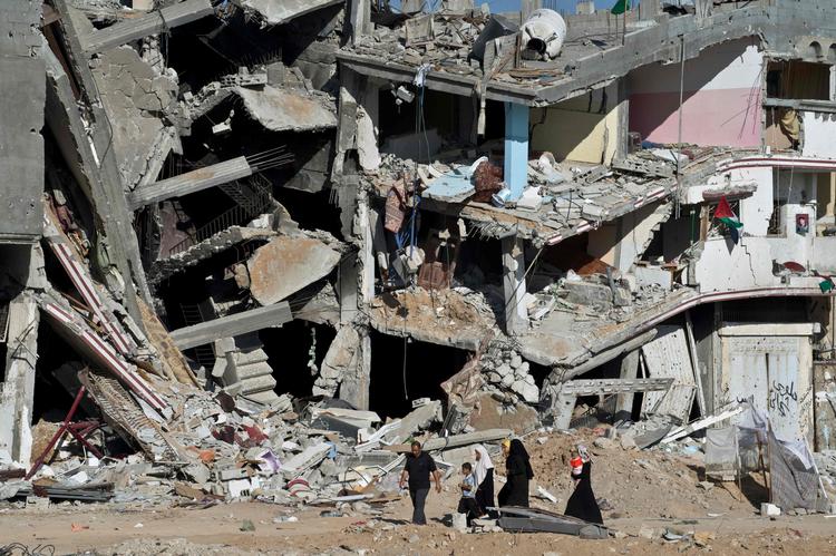Gaza, august 2014 - en palæstinensisk familie passer en ødelagt boligblok under konflikten mellem Hamas-militsen og det israelske militær.  Foto: Roberto Schmidt/Ritzau Scanpix
