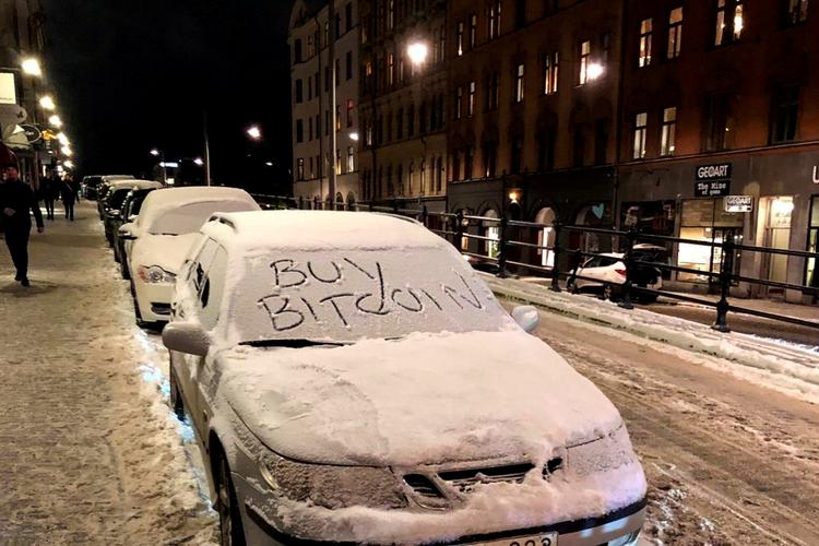 En bil i Stockholm er dekoreret med en opfordring til at købe bitcoins. Det har mange ønsket det seneste år, men kryptovalutaens succes kan give bagslag. Foto: Stringer/Ritzau Scanpix