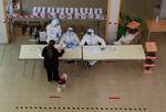  Kun 53 procent af de stemmeberettigede mødte frem, da Katalonien   A woman stands in front of electoral workers at a polling station during regional election in Catalonia, amid the outbreak of the coronavirus disease (COVID-19), in Barcelona, Spain, February 14, 2021. REUTERS/Albert Gea   Foto: Albert Gea/Ritzau Scanpix