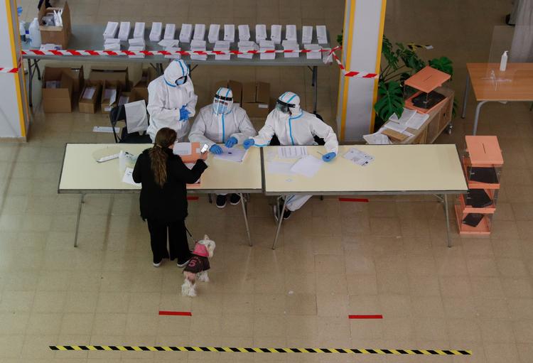  Kun 53 procent af de stemmeberettigede mødte frem, da Katalonien   A woman stands in front of electoral workers at a polling station during regional election in Catalonia, amid the outbreak of the coronavirus disease (COVID-19), in Barcelona, Spain, February 14, 2021. REUTERS/Albert Gea   Foto: Albert Gea/Ritzau Scanpix