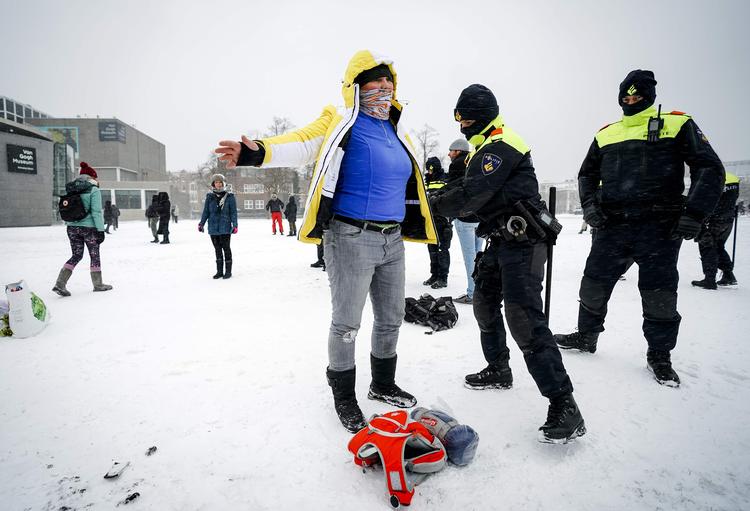 Hollandsk politi kropsvisiterer en demonstrant i Amsterdam før en af de mange demonstrationer, der har plaget landet siden regeringen indførte en række restriktioner sidst i januar.
 Foto: Jeroen Jumelet/Ritzau Scanpix
