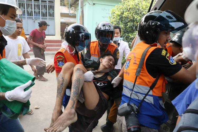 En såret demonstrant bæres væk, efter at politiet lørdag åbnede ild mod demonstranter i Myanmars næststørste by, Mandalay. Foto: Str/Ritzau Scanpix