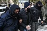 To betjente eskorterer den 56-årige instruktør til retten i Athen. Foto: Aris Messinis/Ritzau Scanpix