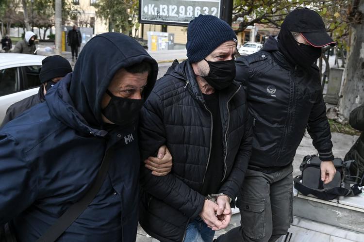 To betjente eskorterer den 56-årige instruktør til retten i Athen. Foto: Aris Messinis/Ritzau Scanpix
