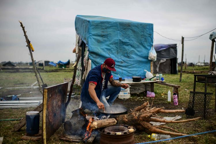 En mand laver mad i et område syd for Argentinas hovedstad, Buenos Aires, hvor der bor mange hjemløse. Fattigdomsraten i Argentina er under coronapandemien vokset til 40 procent.   Foto: Ronaldo Schemidt/Ritzau Scanpix