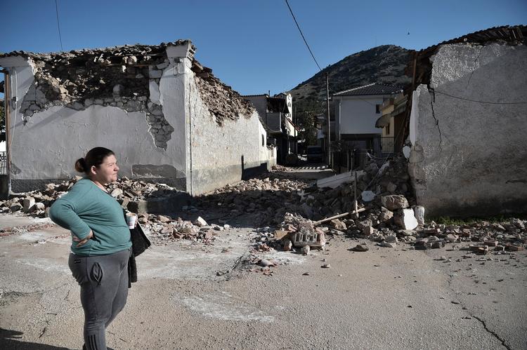 En kvinde står foran et af de huse i landsbyen Damasi nær Tyrvanos, som var blandt de hårdest ramte, da to jordskælv tidligere på ugen forårsagede store ødelæggelser i Grækenland. Foto: Sakis Mitrolidis/Ritzau Scanpix