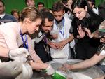 Syriens præsident Bashar al-Assad (nr. 2 fra venstre) og hans kone, Asma (tv.), uddeler nødhjælp til sultne indbyggere i Damaskus. rollen som den alfaderlige landsleder dyrker Assad på Instagram, mens virkeligheden er en ganske anden. Foto: Sana/Ritzau Scanpix