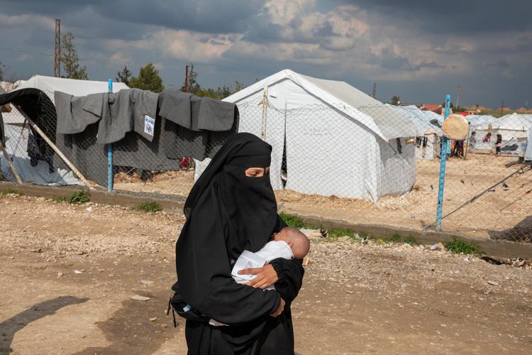     En kvinde af ukendt nationalitet  bærer et spædbarn ind i fremmedsektionen i 2019 i Al-Hol-lejren i det nordlige Syrien.   Foto: Ivor Prickett/Ivor Prickett/The New York Times