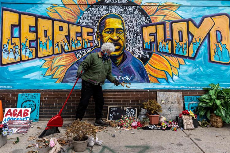 En mand rydder op på 'George Floyd pladsen' - det sted, hvor Floyd døde i maj sidste år, mens han var i politiets varetægt. Foto: Kerem Yucel/Ritzau Scanpix