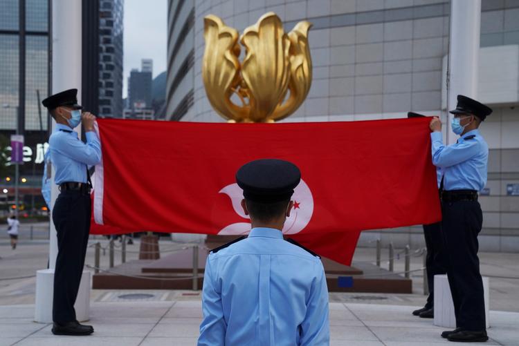 Politifolk under en flagceremoni i Hongkong, der også markerer loyalitet over for Kina. Foto: Lam Yik/Ritzau Scanpix
