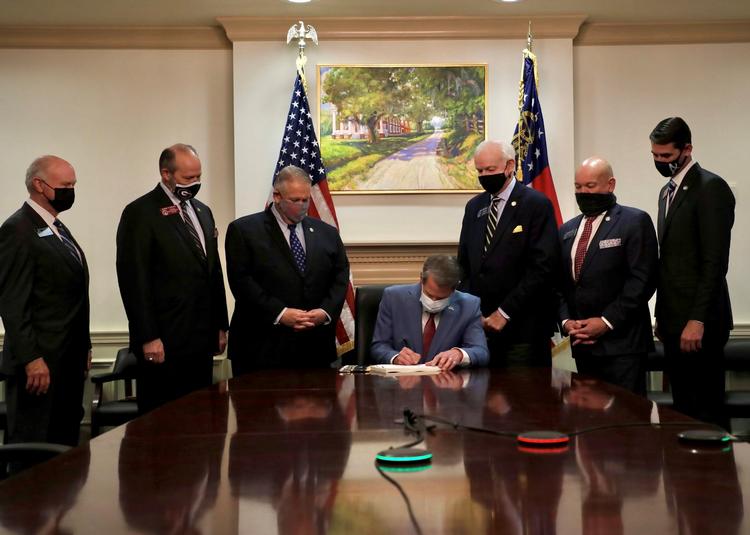 SEJR. Georgias guvernør Brian Kemp 
(siddende) underskriver en ny valglov, der reelt vil reducere valgdeltagelsen. Og loven vil særligt ramme sorte og andre minoriteter, lyder vurderingen. Foto Governor Brian Kemp's Twitter Fe