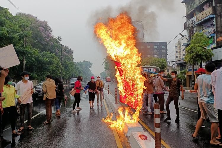    Demonstranter i byen Yangon i Myanmar afbrændte mandag kinesiske flag i protest mod Kinas støtte til det blodige militærdiktatur. Foto: Stringer/Ritzau Scanpix