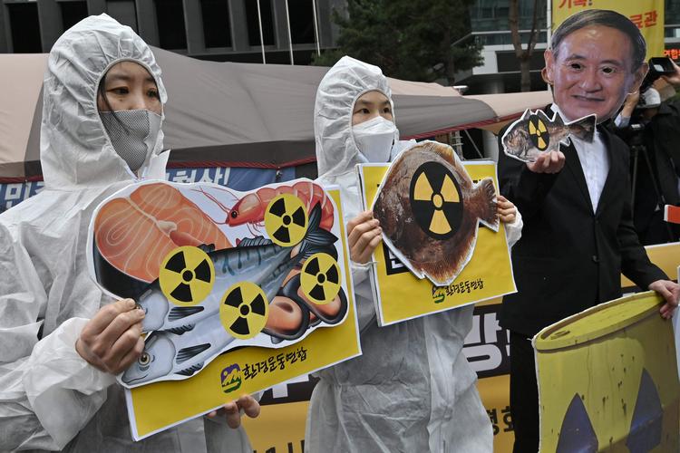 Sydkoreanske miljøaktivister demonstrerer foran Japans ambassade i Seoul. Den maskeklædte til højre forestiller Japans regeringschef, Yoshihide Suga. Foto: Jung Yeon-je/Ritzau Scanpix