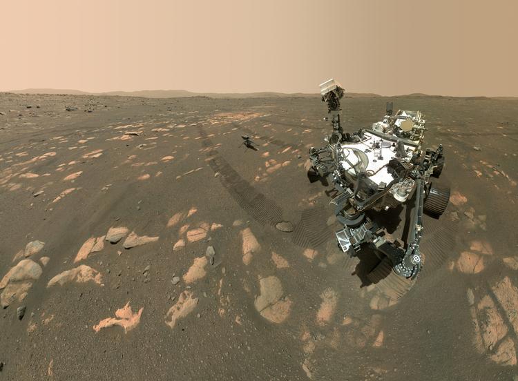 Mars-roveren bruger ikke kun sine kameraer til at rekognoscere det røde støv på planeten. Den tager også selfies, hvor man kan se den lille følgesvend i form af helikopteren 'Ingenuity' i baggrunden. Robotarmen, der holder kameraet - eller selfiestangen, om man vil - er ikke med på dette billede, fordi det er sammensat af 62 individuelle billeder taget på missionens 46. Mars-dag. Foto: Nasa