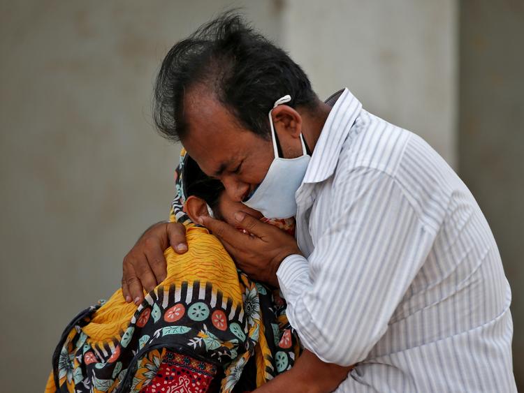 En kvinde trøstes af en slægtning efter manden er død af covid-19. Foto taget mandag den 26. april i Ahmedabad, Indien. REUTERS/Amit Dave   Foto: Amit Dave/Ritzau Scanpix