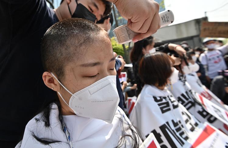 Universitetsstuderende i Seoul får barberet håret af foran den japanske ambassade i protest mod Japans beslutning om at udlede forurenet vand Foto: Jung Yeon-je/Ritzau Scanpix