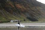 I tykke våddragter bevæger surfere sig ud i vilde bølger. Der kan være en del strøm i havet, så det er en god ide at have en instruktør med, der kender bølgerne.  