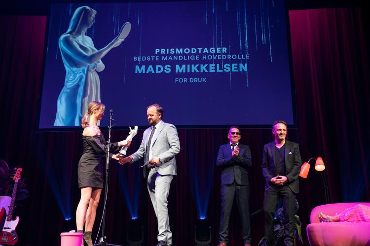 Mads Mikkelsen modtog statuetten for Bedste Mandlige Hovedrolle, men var ikke tilstede ved prisuddelingen. Her tager Magnus Millang imod statuetten på vegne af Mads Mikkelsen. Uddeling af Bodilprisen 2021 foregik i Folketeatret i København. Foto: Claus Bech/Ritzau Scanpix