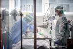 Læger tilser en patient i Wuhan 19. marts sidste år, hvor byen var hårdt ramt af corona.  Foto: Claudio Furlan/AP/Ritzau Scanpix