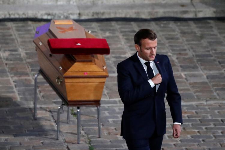 Den franske præsident Emmanuel Macron ved kisten med den myrdede lærer Samuel Paty. Han blev myrdet i en forstad til Paris.  Foto: Pool/Ritzau Scanpix