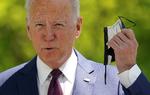 Præsident Biden tager sit mundbind af under en tale om nye anbefalinger om mundbindsbrug i USA. REUTERS/Kevin Lamarque/File Photo Foto: Kevin Lamarque/Ritzau Scanpix