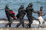  Spanske tropper bærer og eskorterer marokkanske migranter væk fra El Tarajal beach nær den spansk-marokkanske grænse. Spaniens premierminister, Pedro Sánchez, har lovet at genoprette roen i den spanske enklave Ceuta i Marokko. Foto: Jon Nazca/Ritzau Scanpix