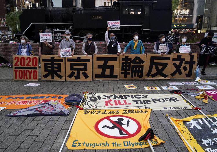 En gruppe japanere demonstrerer i Tokyo mod OL. På skiltene står der 'Imod Tokyo OL'. Foto: Naoki Ogura/Ritzau Scanpix
