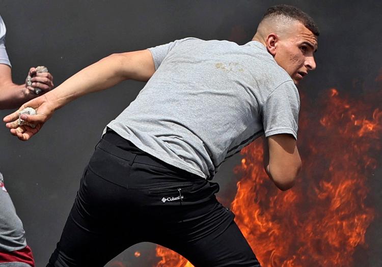 Palæstinensiske demonstranter kaster med sten mod israelske sikkerhedsstyrker i Jerusalem fredag.  Foto: Jaafar Ashtiyeh/Ritzau Scanpix