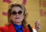 Mange har skrottet cigaretter de seneste år, men i fransk film pulses der stadig løs. Her ses den franske filmstjerne  Catherine Deneuve med en cigaret i hånden - dog ikke i en film, men under et pressemøde ved Berlinalen. Foto: Tom Maelsa/Ritzau Scanpix