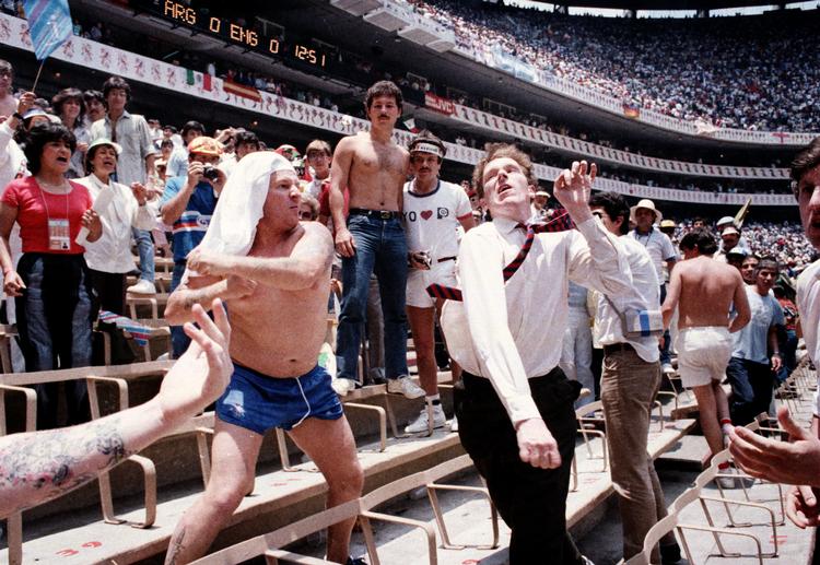 VM-kvartfinalen mellem Argentina og England i 1986 blev som en genopførelse af Falklandskrigen fire år tidligere, også blandt tilskuerne, hvor vi her ser en engelsk fan slå en argentiner.  Foto: Sergio Dorantes/Ritzau Scanpix