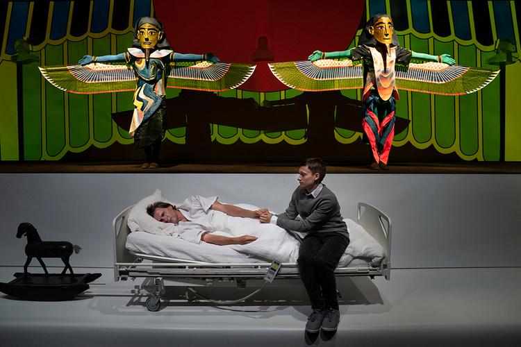 Nederst på den 28 meter brede scene, der ligner en hospitalsgang, ligger faren på sit dødsleje med sønnen ved sin side, mens der lige over dem findes en mytologisk verden af guder og dyreskikkelser. Foto: Karoline Lieberkind