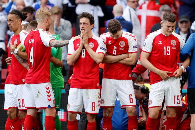     Billedet af en lørdag aften, vi aldrig glemmer. Danske spillere, knugede af bekymring, dækker for Christian Eriksens kamp for livet.  Foto Jens Dresling