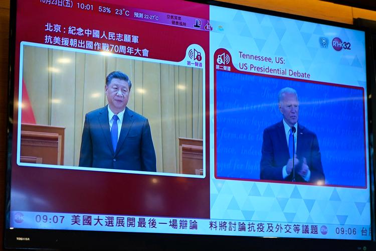 En tv-station i Hongkong samlede i oktober billederne af præsident Xi Jinping der talte ved en konference i Kina, og daværende præsidentkandidat Joe Biden, der deltog i en valgdebat i USA. Deres to lande er i stigende grad uenige om sikkerhedsspørgsmål. Foto: Kin Cheung/Ritzau Scanpix
