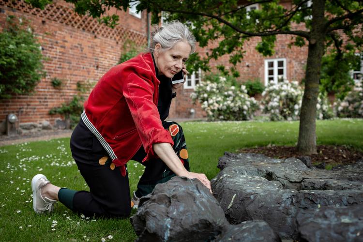 Sognepræst og en af folkene bag de nye Danske Digterruter, Bente Bramming, er taget med på ruten om Ambrosius Stub i Ribe, her ved Per Kirkebys gravmonument for digteren i Sct. Catharinæ Klosterhave i Ribe. Foto: Astrid Dalum