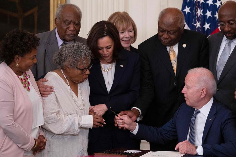 Vicepræsident Kamala Harris i midten ser på, mens Opal Lee får kuglepennen, som præsident Joe Biden har brugt til at underskrive loven om Juneteenth.  Foto: Jim Watson/Ritzau Scanpix